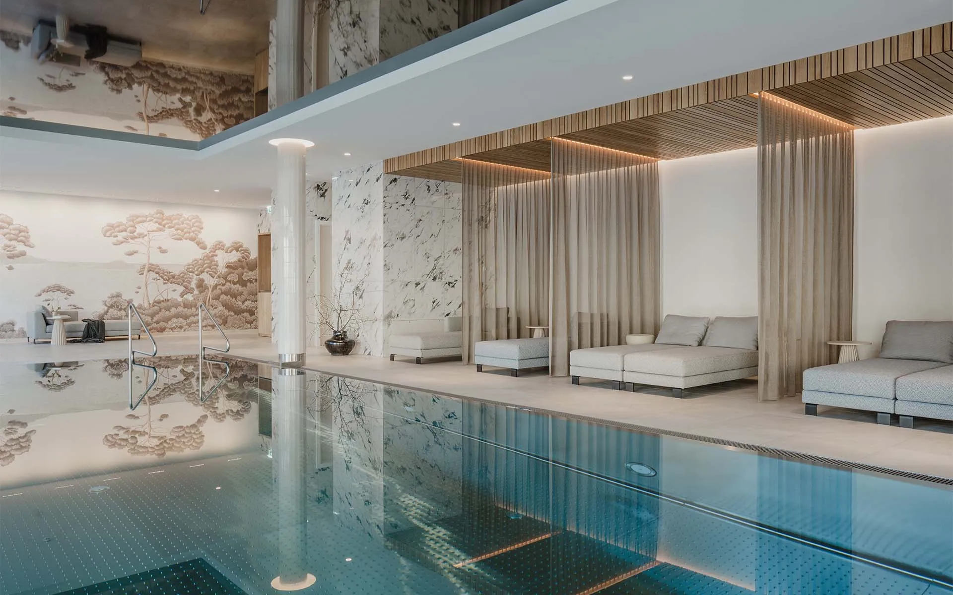 Wellnessbereich im Grand Elisabeth Hotel mit Liegen, Vorhängen und Marmorwänden