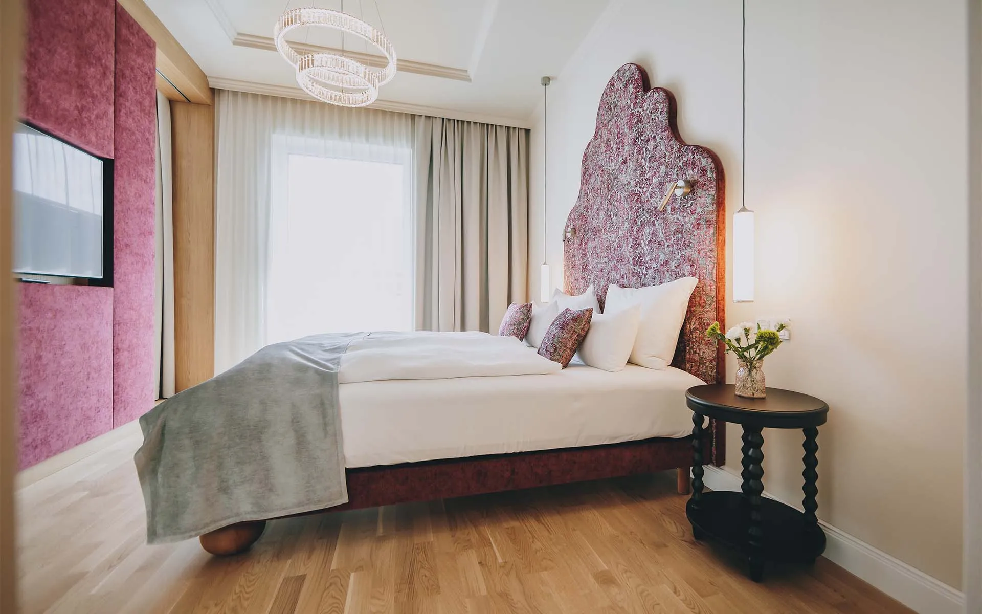 Wellnessurlaub Salzkammergut: stilvolles Schlafzimmer mit floraler Stoffwand und Licht