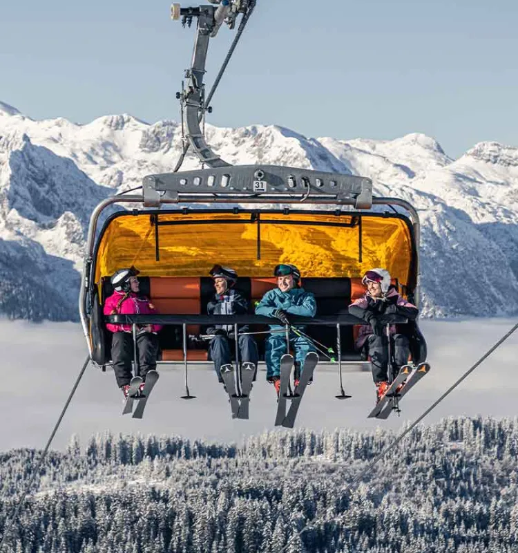 Skiers in chairlift Dachstein West during Snow Adventure ski holiday Grand Elisabeth Hotel Salzkammergut Austria