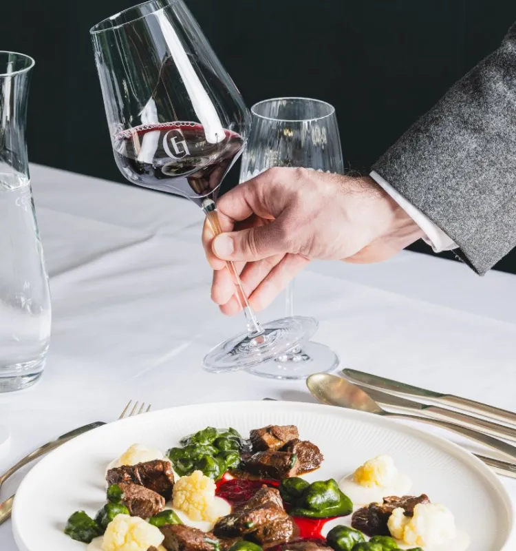 Ein Teller mit einem köstlichen Gericht und ein Glas Rotwein