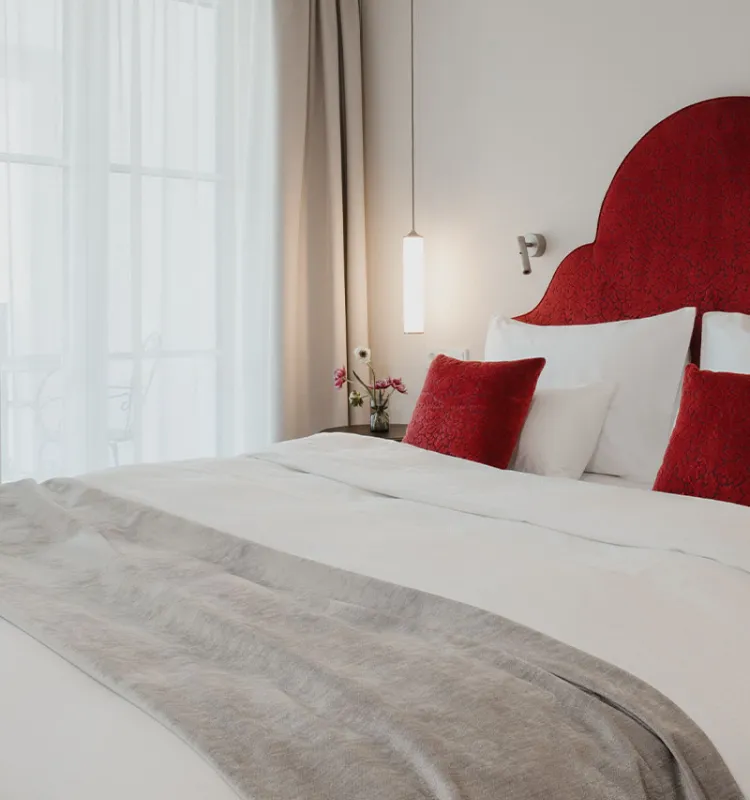 Elegantes Zimmer mit rotem Kopfteil am Doppelbett im Designhotel Grand Elisabeth Bad Ischl