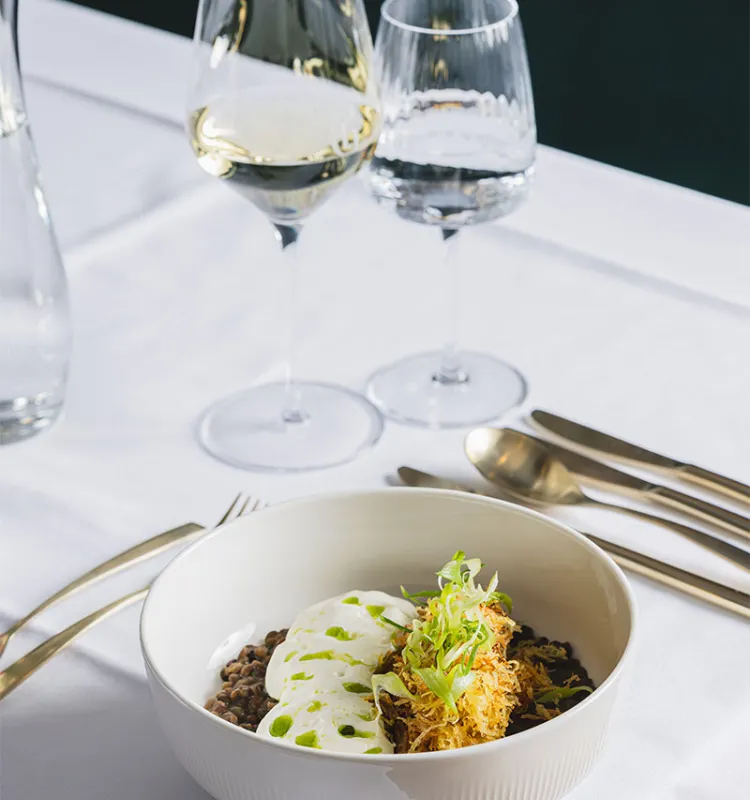 Set table with main course and wine at Grand Elisabeth Designhotel