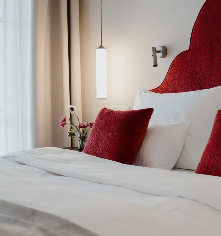 Detailansicht eines Bettes mit roten Akzenten im Designhotel Grand Elisabeth