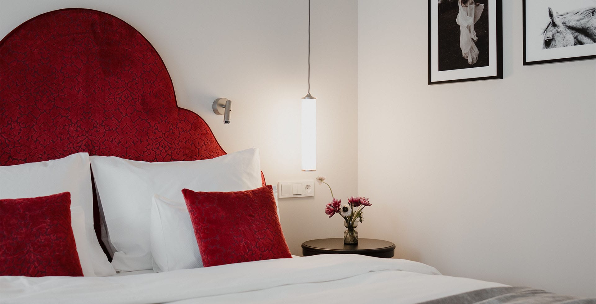 Rotes Kopfteil mit Wandbildern im Grand Elisabeth Hotel Bad Ischl nahe Balkon
