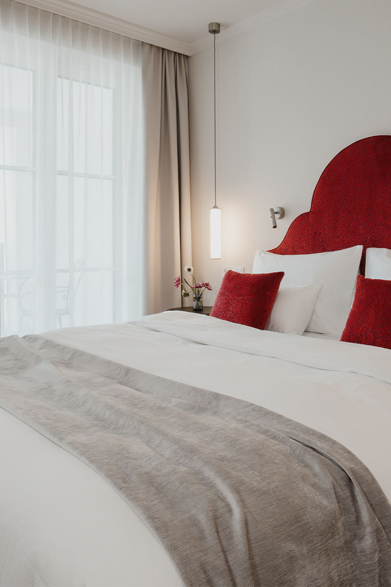 Elegantes Zimmer mit rotem Kopfteil am Doppelbett im Designhotel Grand Elisabeth Bad Ischl