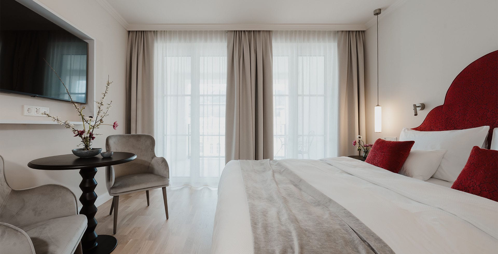 Gesamtansicht des Doppelzimmers mit TV und Balkon im Grand Elisabeth Hotel