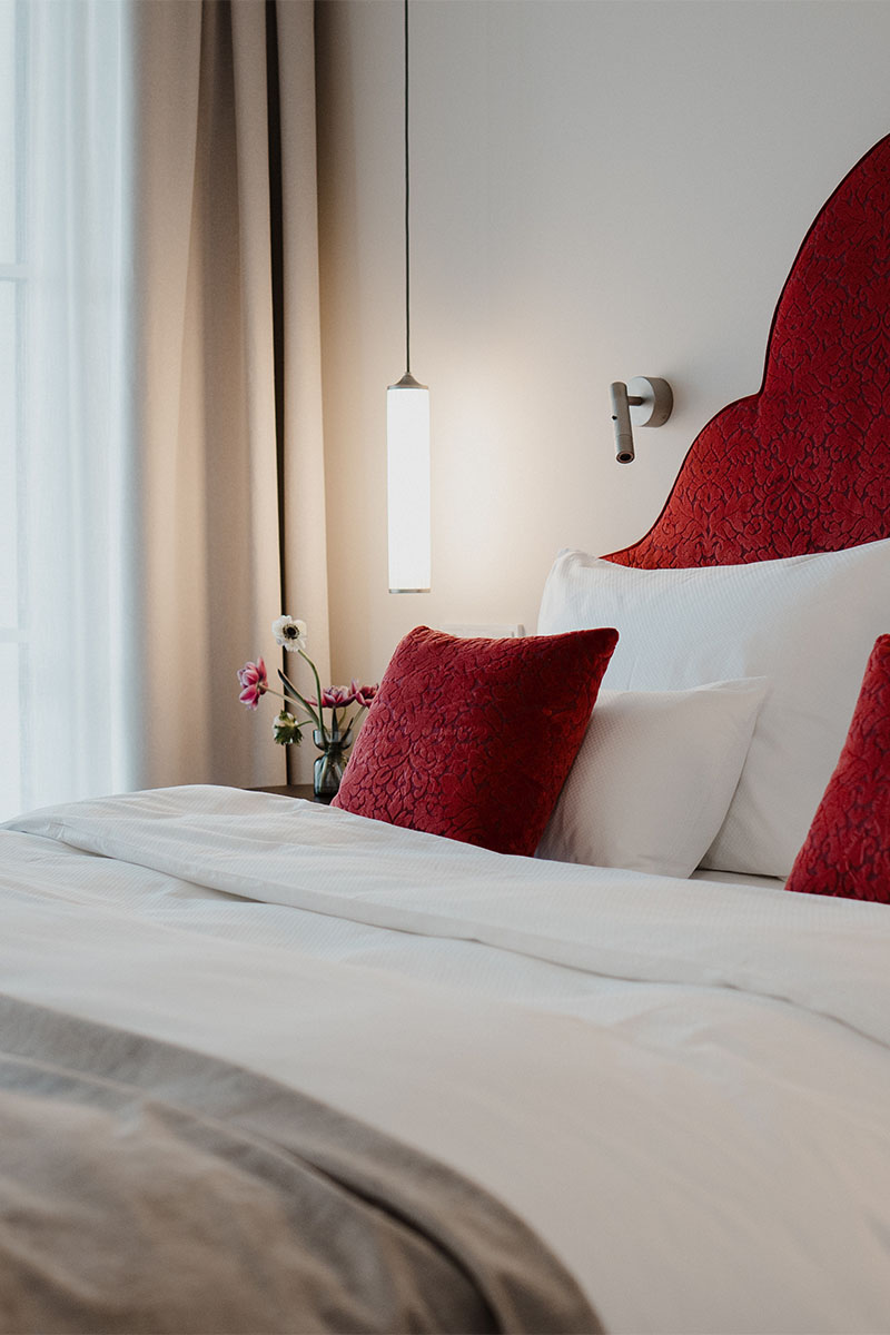 Detailansicht eines Bettes mit roten Akzenten im Designhotel Grand Elisabeth