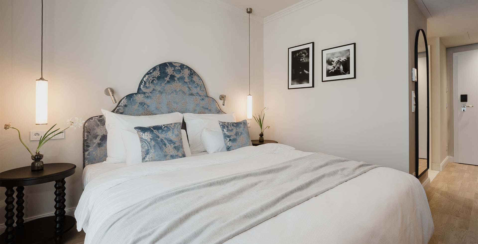 Blick auf das klassische Doppelzimmer im Hotel Bad Ischl mit blauen Kissen und floralen Details