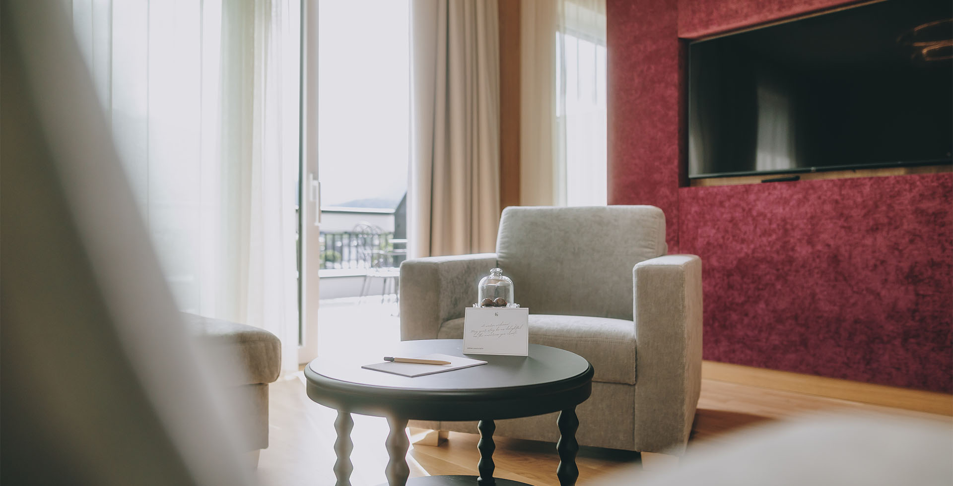 Sitzecke der Kaiser Suite im Grand Elisabeth mit Tisch, Grußkarte und Sessel