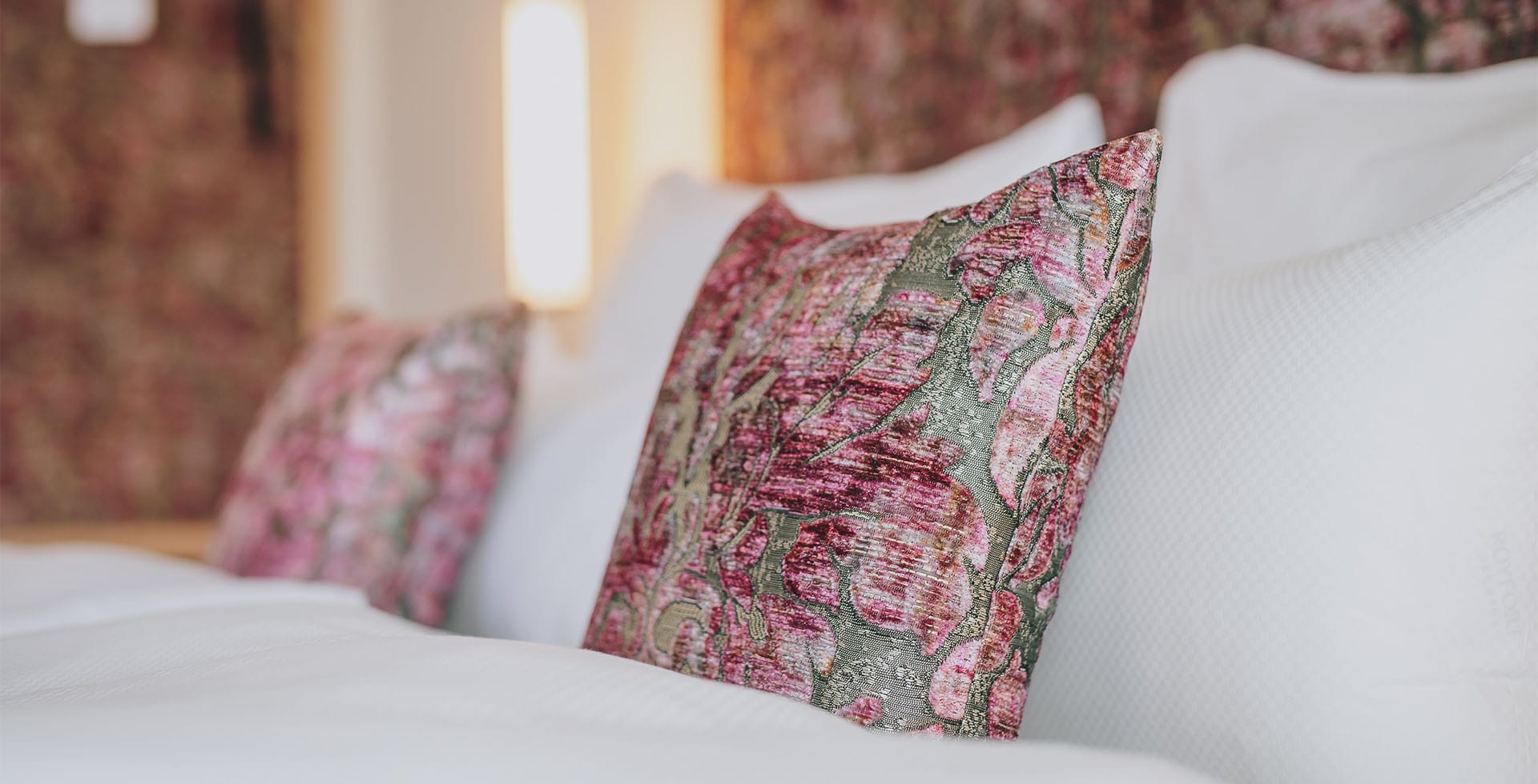 Detailaufnahme eines Dekokissens mit floralen Muster im Designhotel Bad Ischl