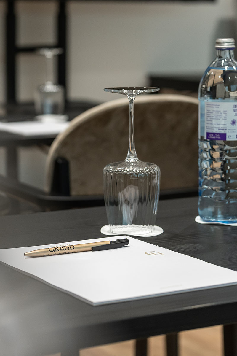 Konferenztisch mit Wasserflasche, Glas und Schreibblock im Grand Elisabeth