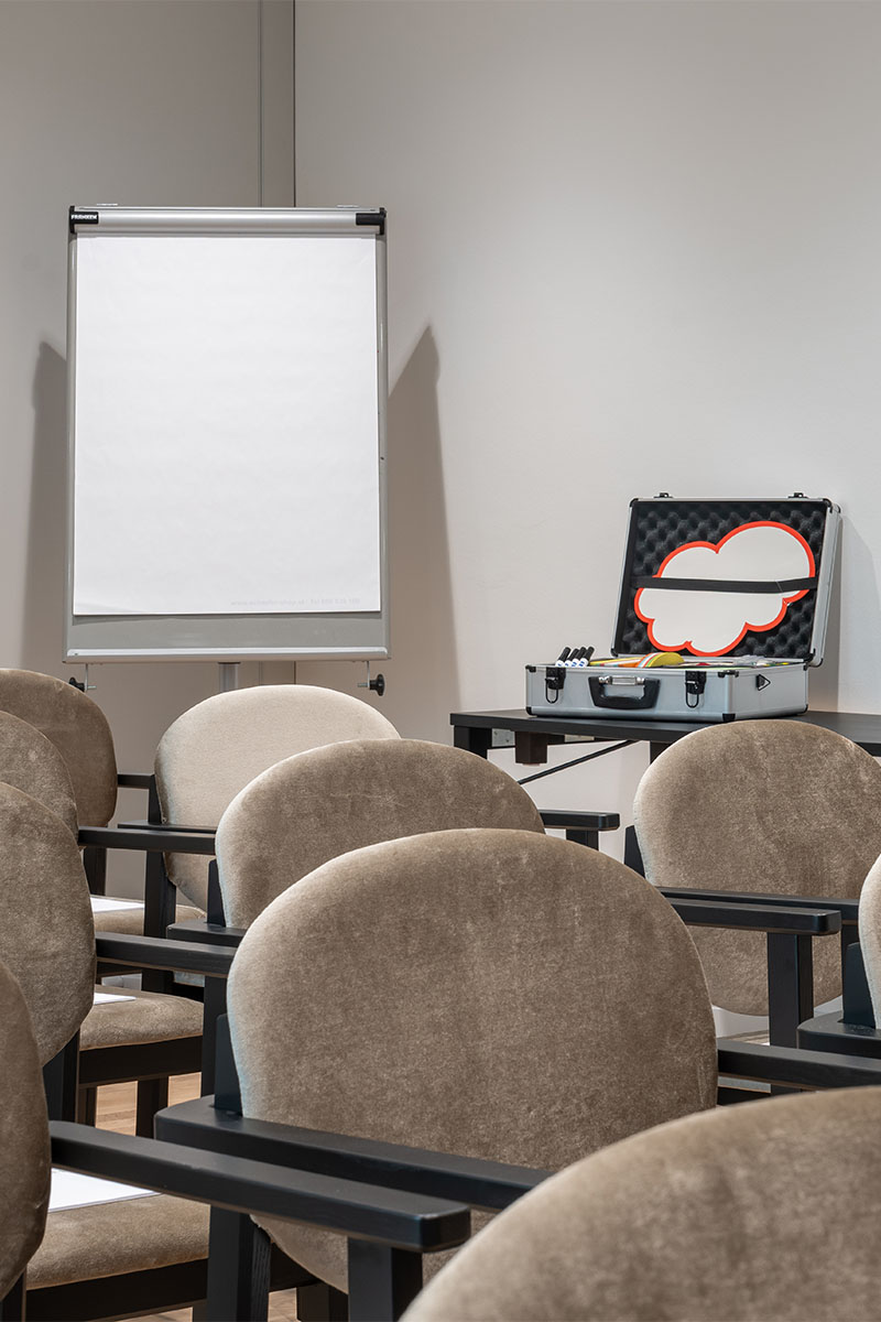 Moderationskoffer und Stuhlreihen im Grand Elisabeth Bad Ischl mit Flipchart im Hintergrund