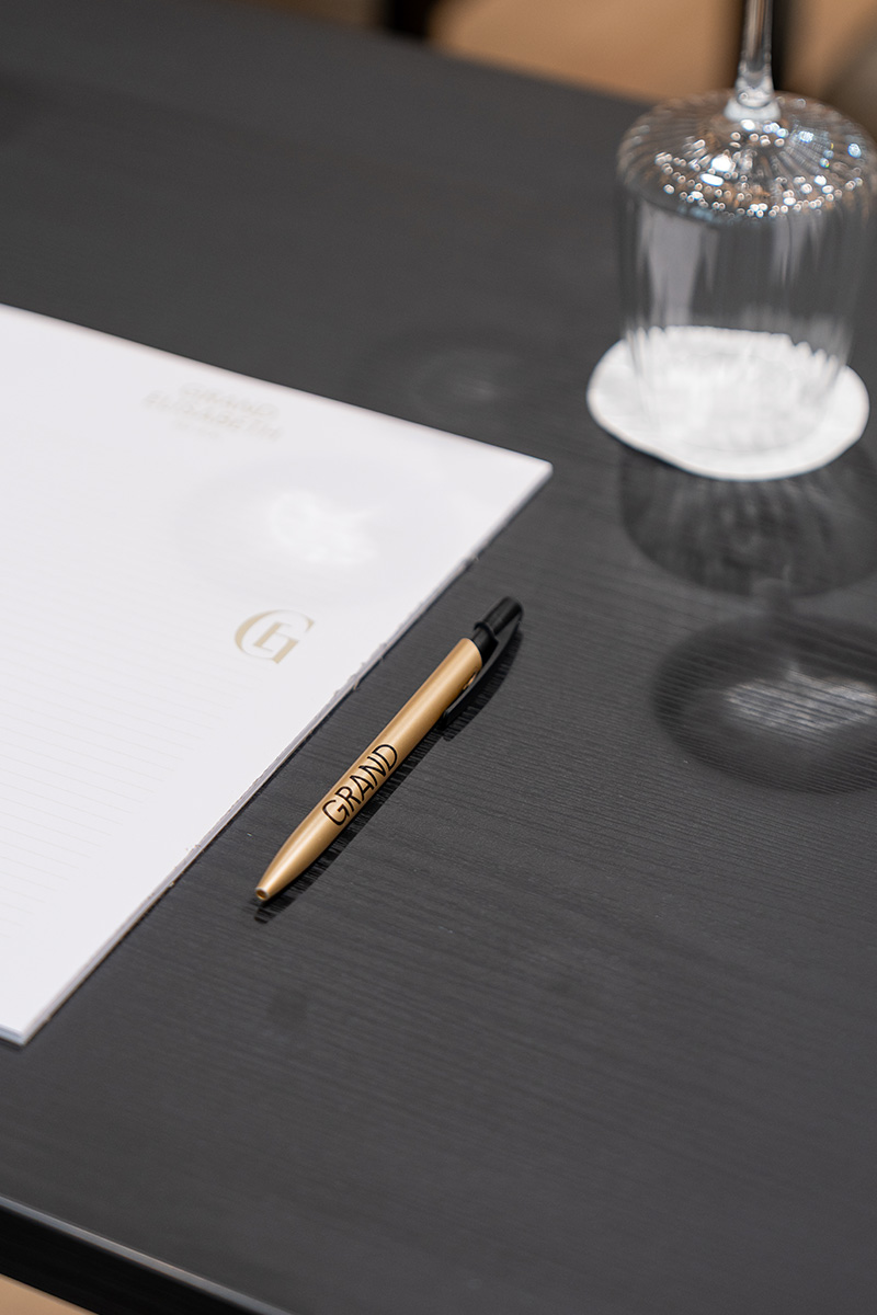 Schreibutensilien und Glas auf Tisch im Seminarraum des Grand Elisabeth Hotel Bad Ischl