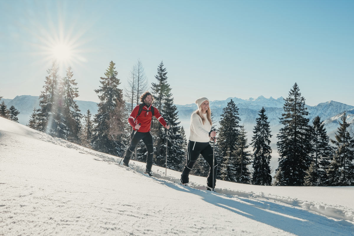 Two people winter hiking in the snowy mountain landscape of the Bad Ischl region