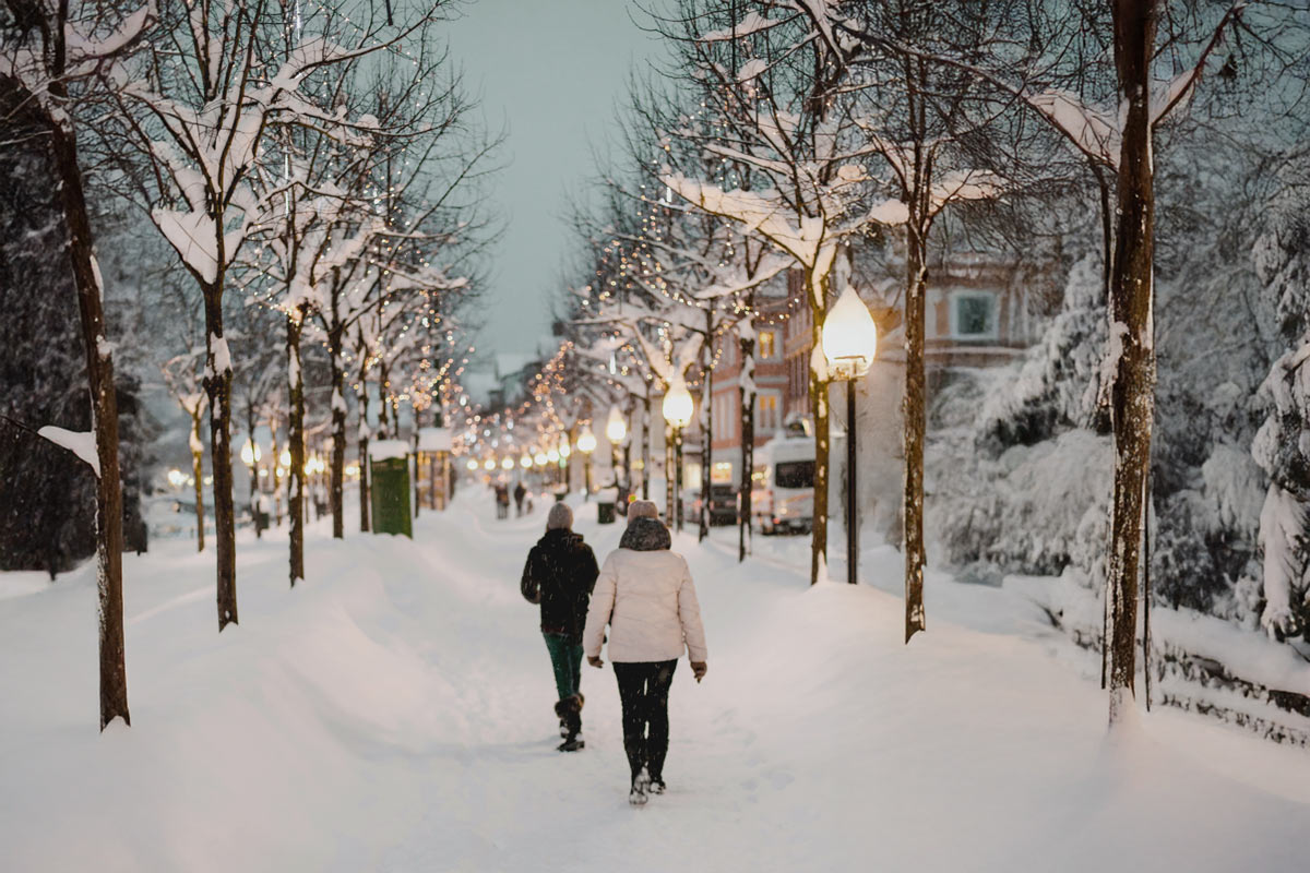 Snow covered walkway with lights in Bad Ischl near Hotel Grand Elisabeth in the evening
