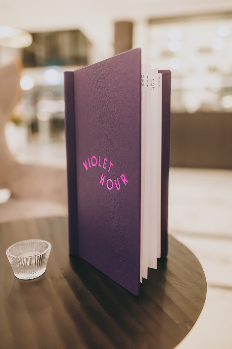 Die stilvolle Cocktailkarte der Hotelbar Violet Hour mit geprägtem Logo in Pink